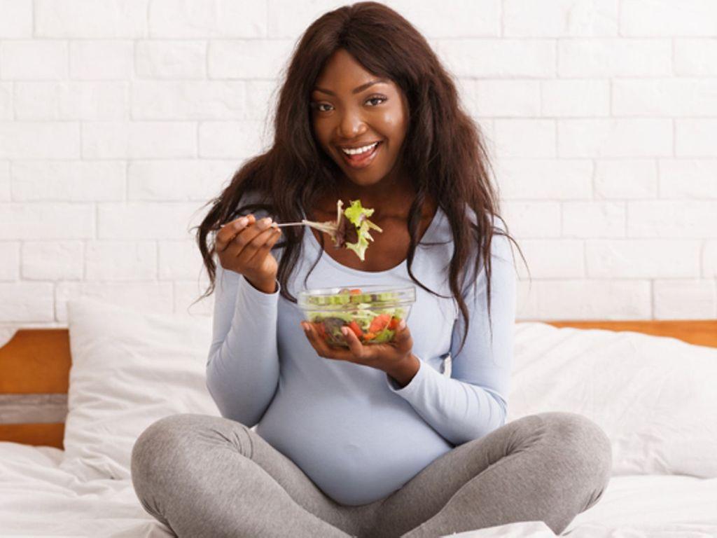 Vitamine in der Schwangerschaft: Eine Schwangere isst Salat