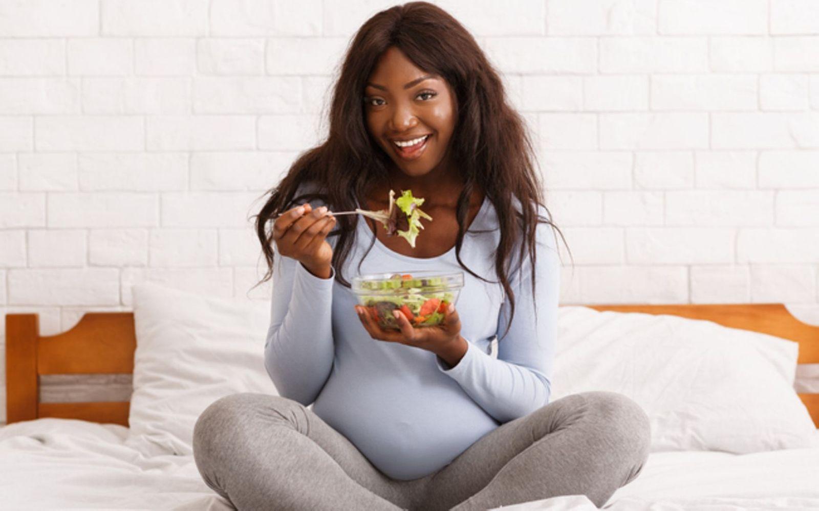 Vitamine in der Schwangerschaft: Eine Schwangere isst Salat