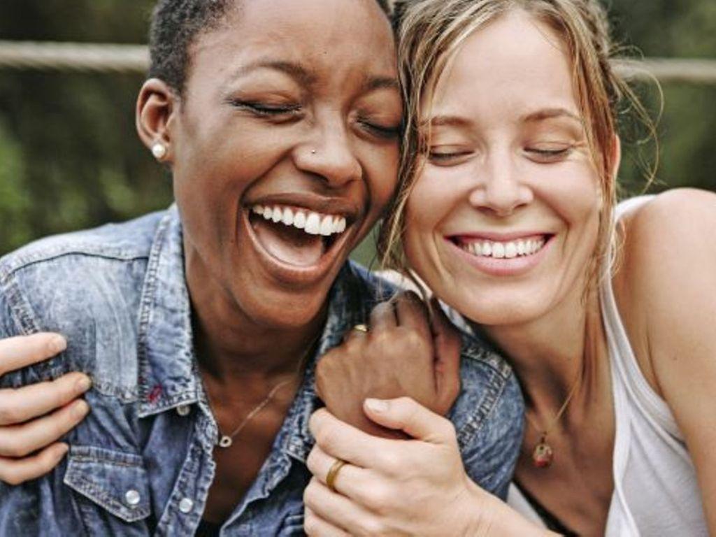 Gesundheit beginnt im Kopf: Zwei Frauen, die sich in den Arm nehmen und lächeln.