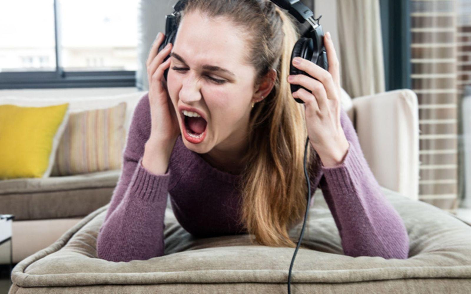 Tinnitus: Mädchen hört zu laut Musik und nimmt erschrocken die Kopfhörer ab