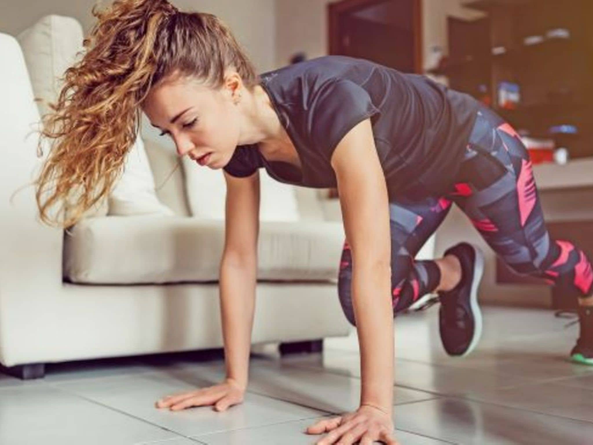 Symbolfoto für Fit im Homeoffice: Eine Frau macht zuhause Gymnastik