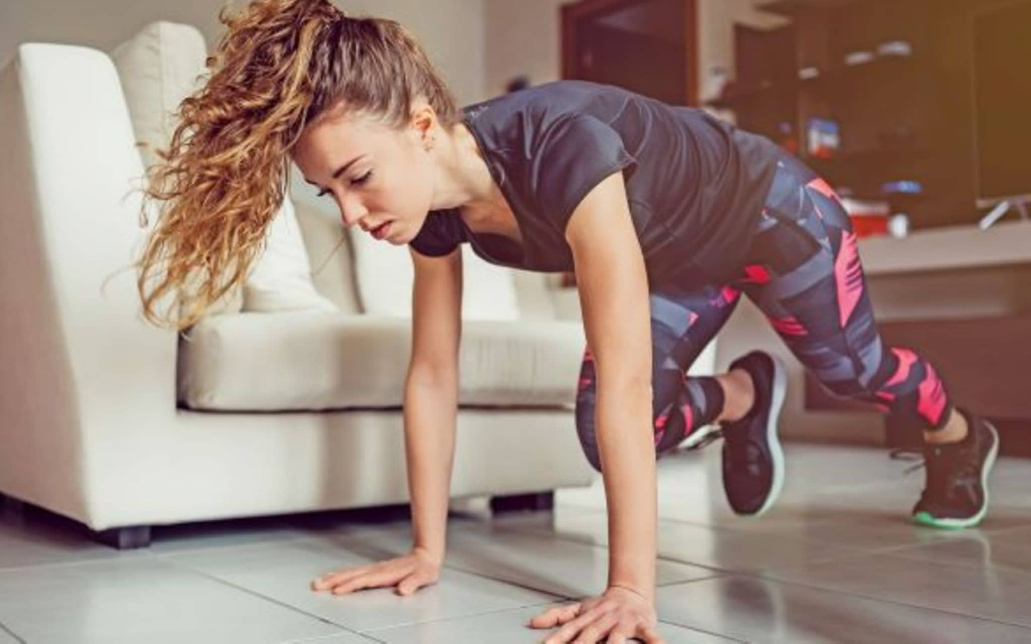Symbolfoto für Fit im Homeoffice: Eine Frau macht zuhause Gymnastik