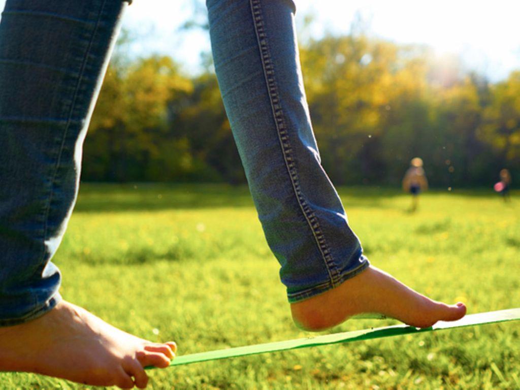 Outdoorspiele für Erwachsene: Ein Mensch balanciert auf der Slackline