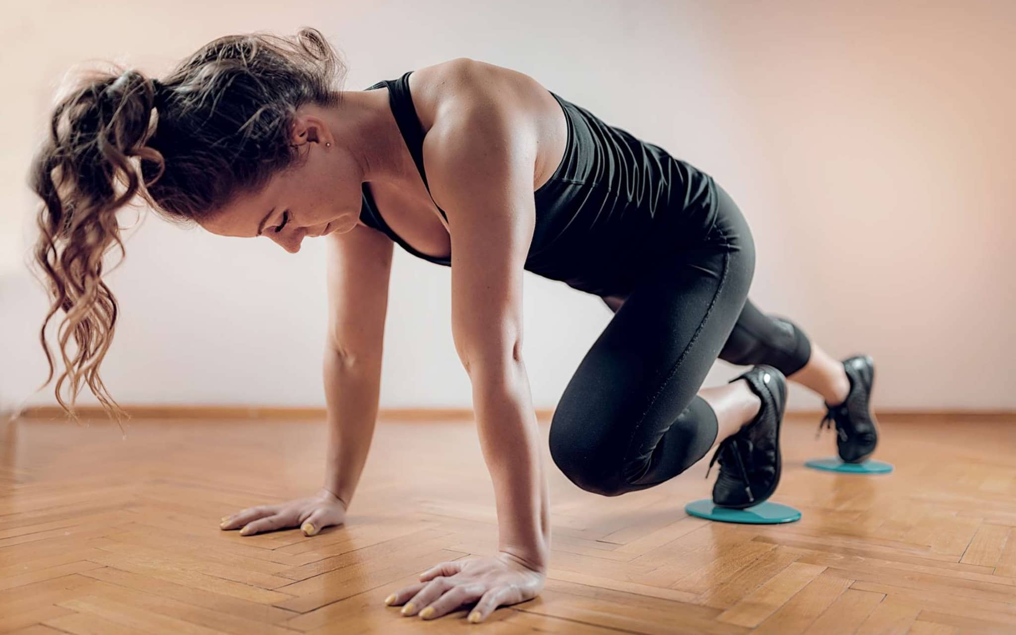 Slide-Training: Eine junge Frau trainiert mit Gleitscheiben.
