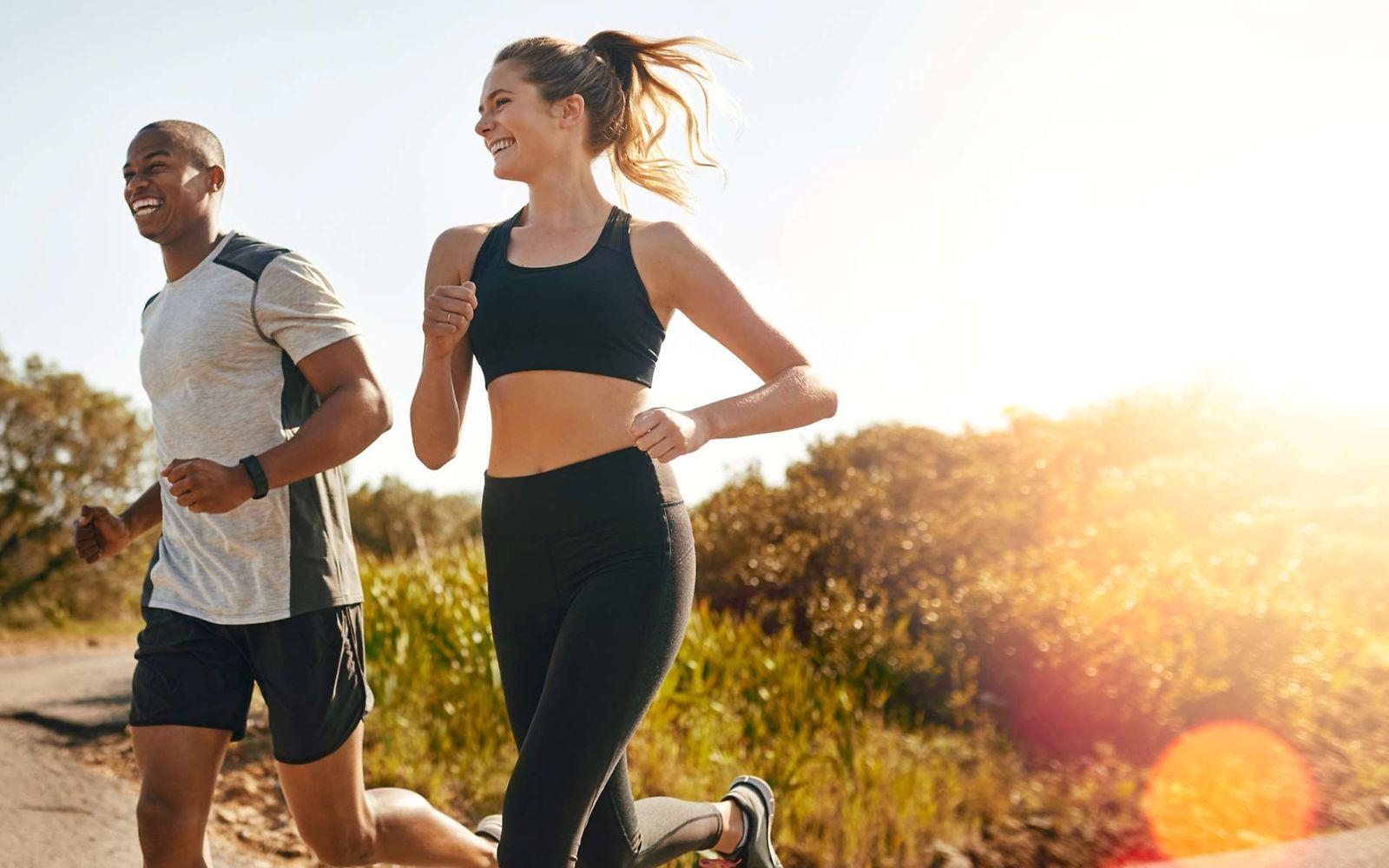 Marathon: Eine Frau und ein Mann joggen gemeinsam durch die Natur.