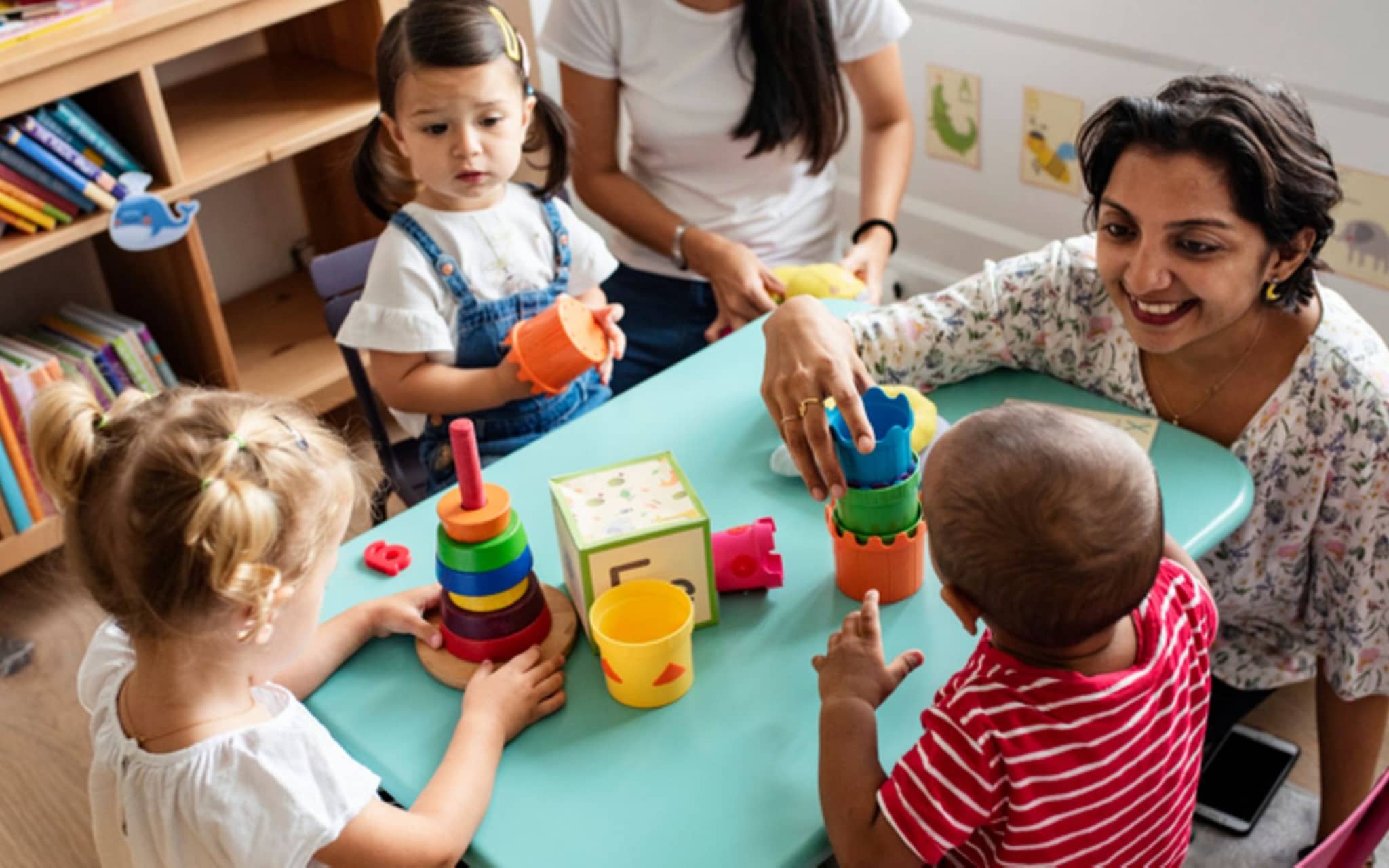 Erzieherin spielt mit Kindern in einer zweisprachigen Kita