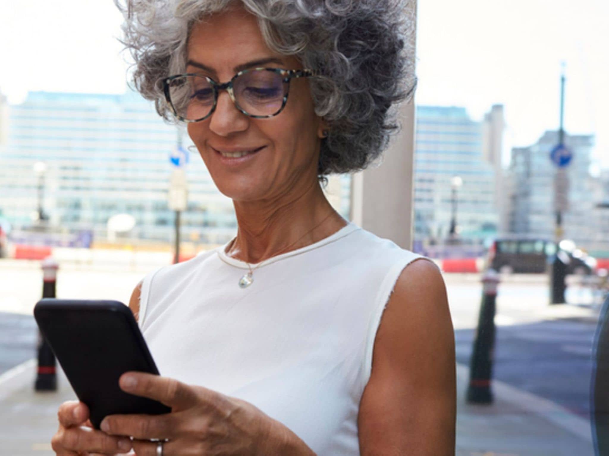 Frau mit Smartphone in Stadtstraße, Nahaufnahme