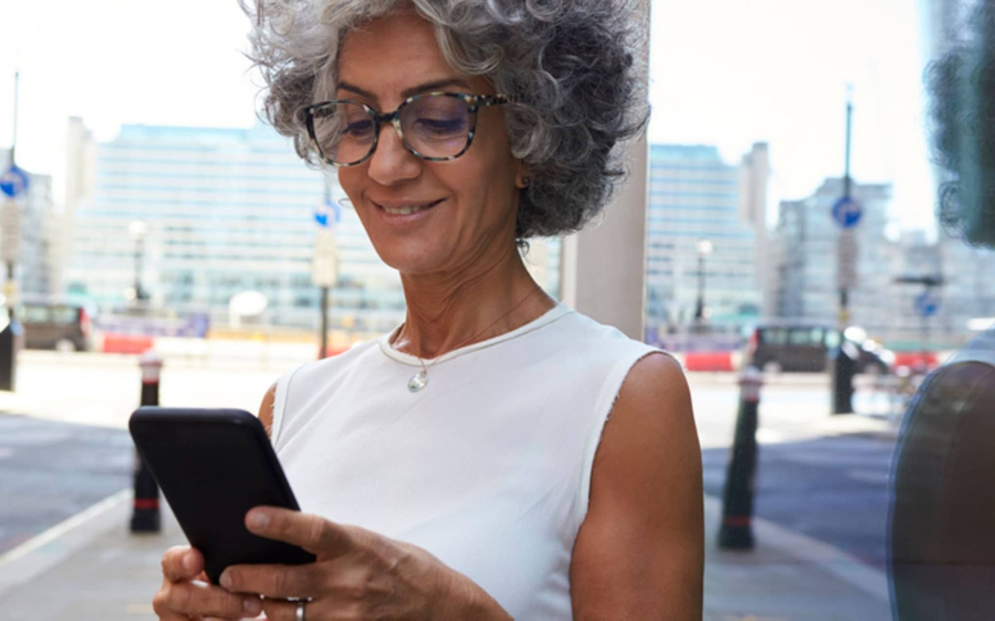 Frau mit Smartphone in Stadtstraße, Nahaufnahme