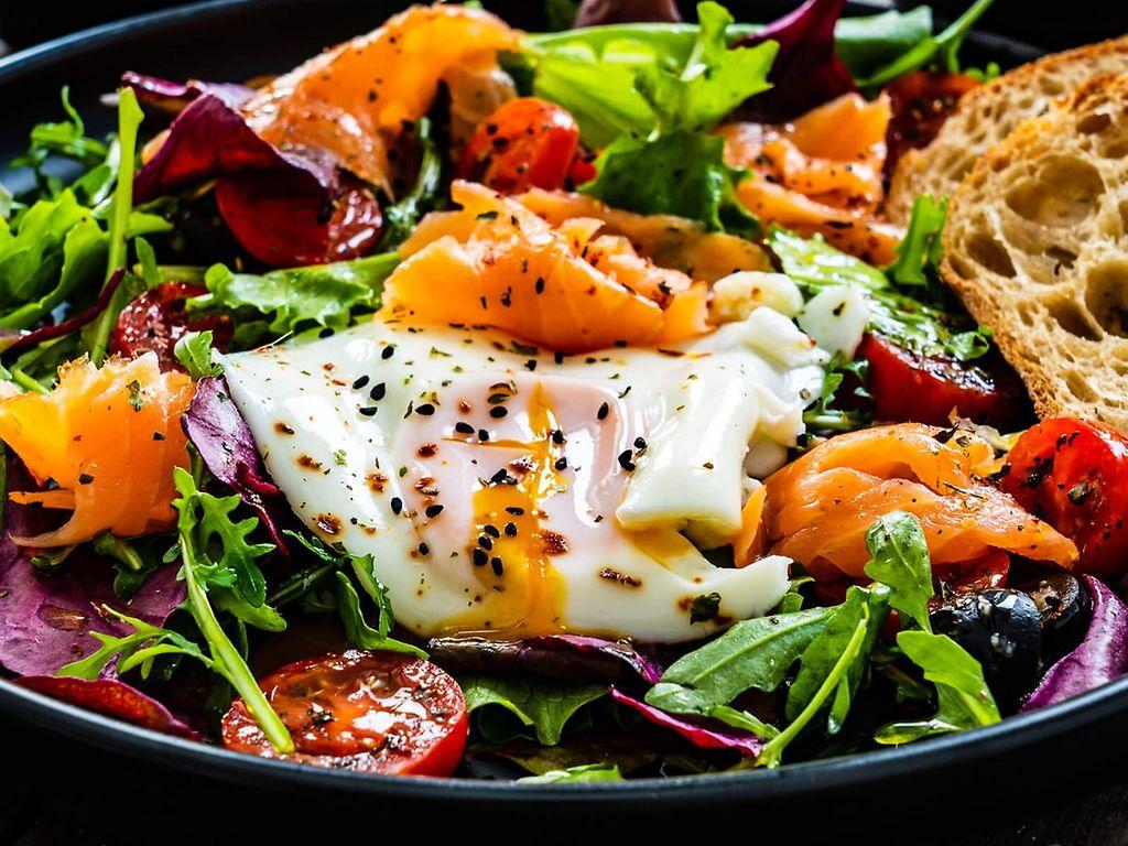 Makronährstoff Eiweiß: Bild von einem Salat mit weichem Ei, Lachs und einer Scheibe Brot.