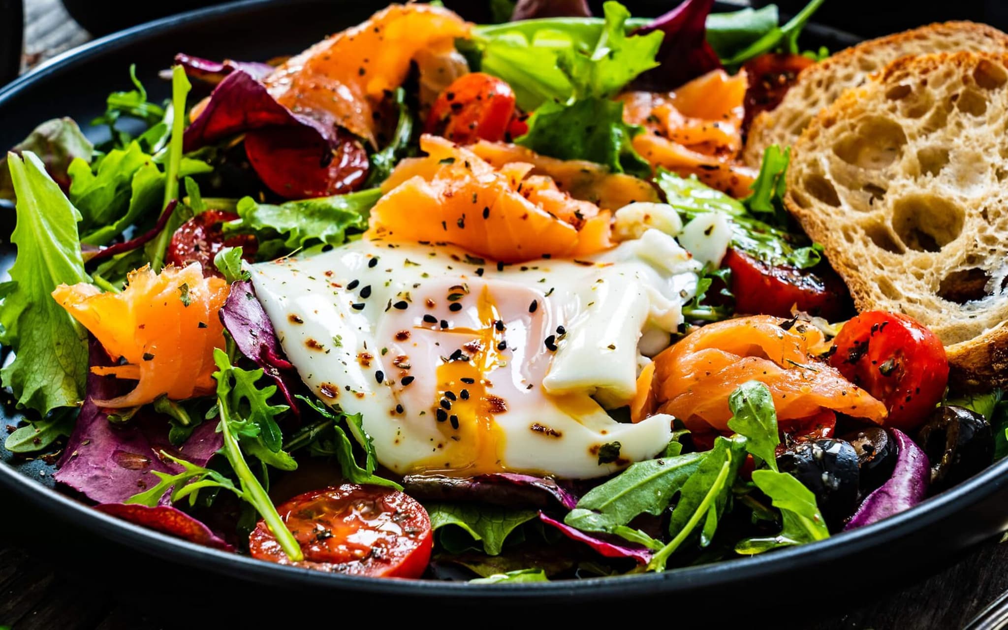 Makronährstoff Eiweiß: Bild von einem Salat mit weichem Ei, Lachs und einer Scheibe Brot.