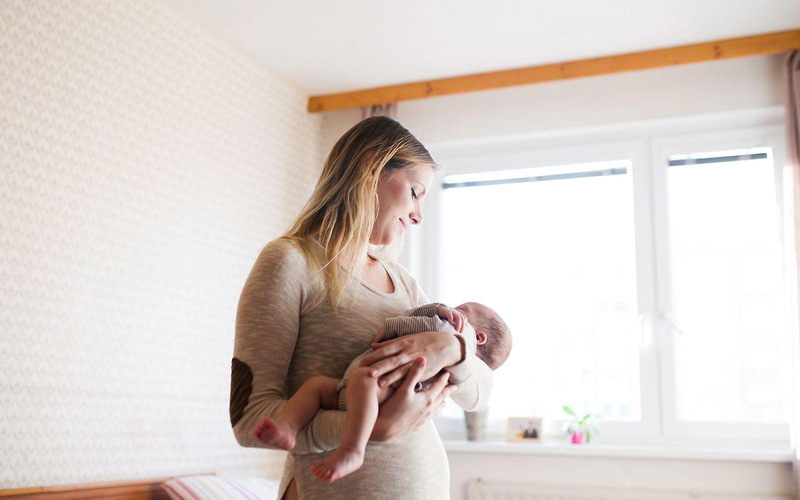 Körper nach der Geburt: Eine Mutter hält ihr neugeborenes Baby im Arm