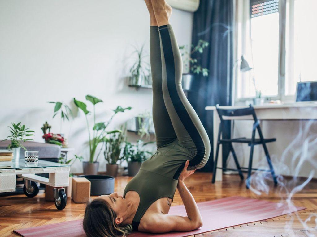 Bandscheibenvorfall: Frau macht Yoga-Übung auf der Matte, um einem Bandscheibenvorfall vorzubeugen