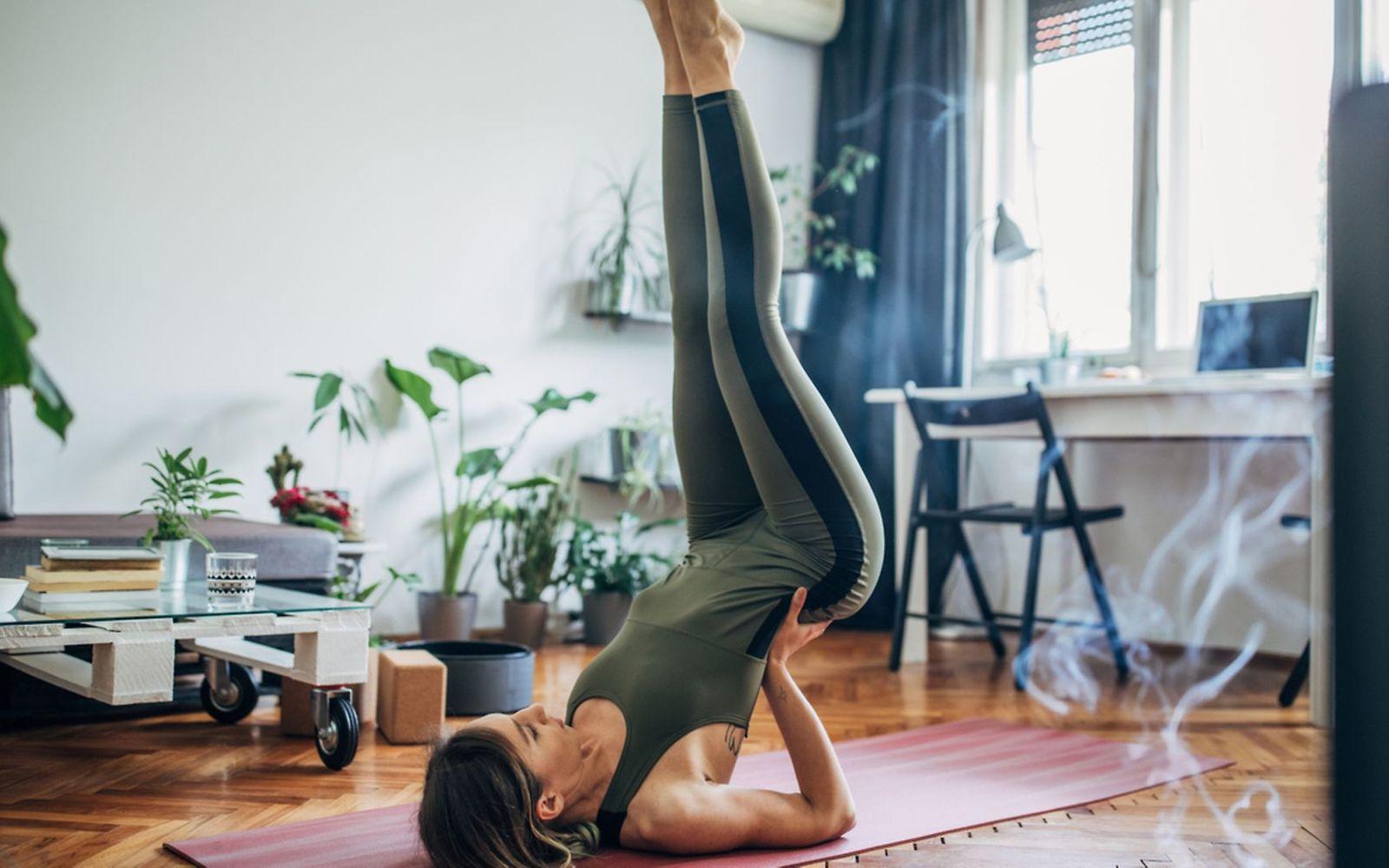 Bandscheibenvorfall: Frau macht Yoga-Übung auf der Matte, um einem Bandscheibenvorfall vorzubeugen