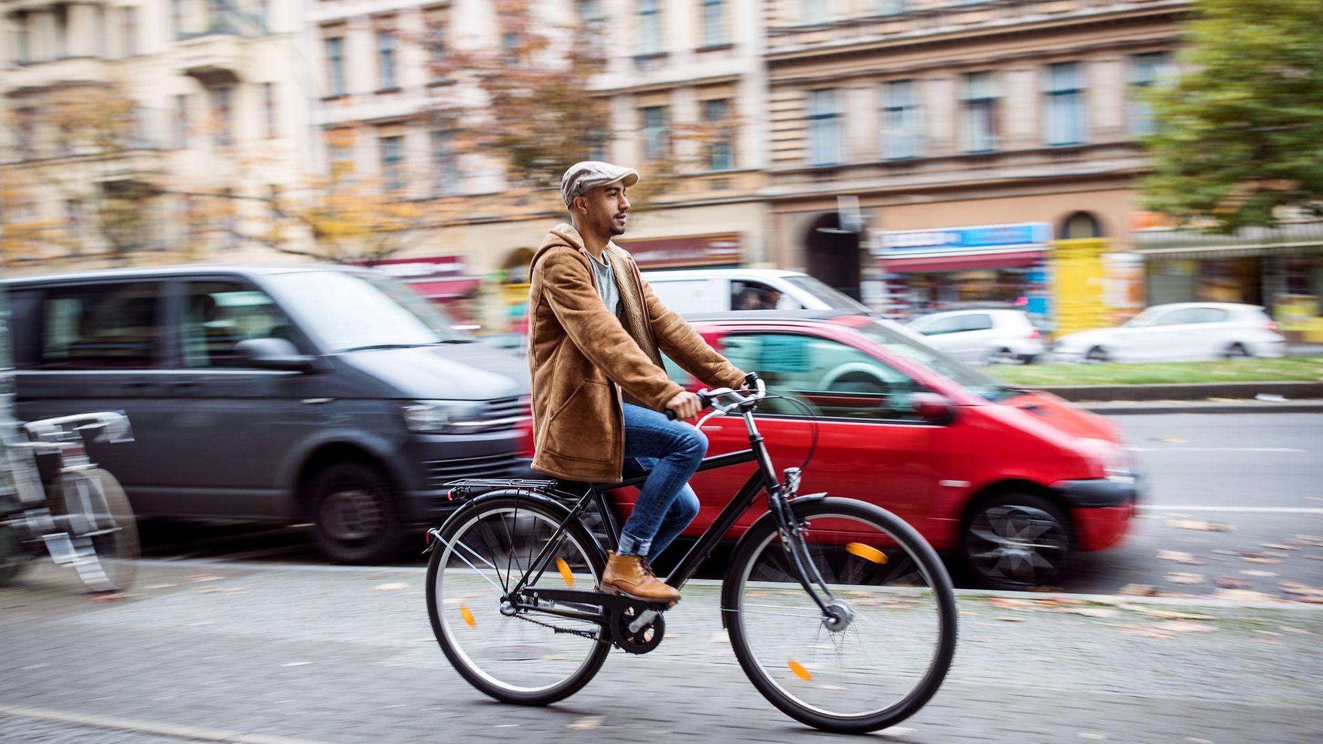 Herz-Kreislauf-Erkrankungen: Mann fährt mit dem Rad durch eine Stadt.