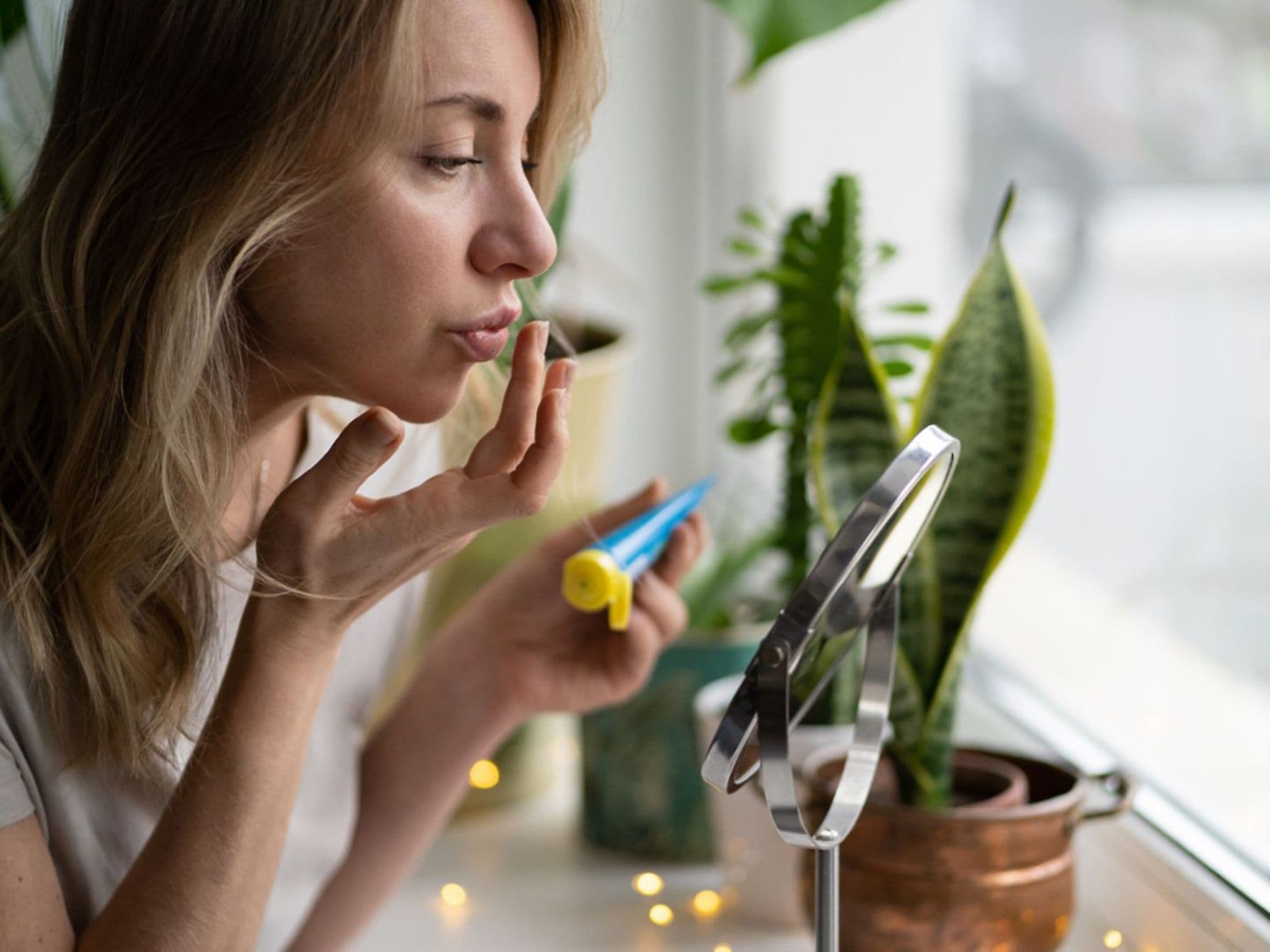 Lippenherpes: Frau cremt ihre Lippen mit einer Salbe ein