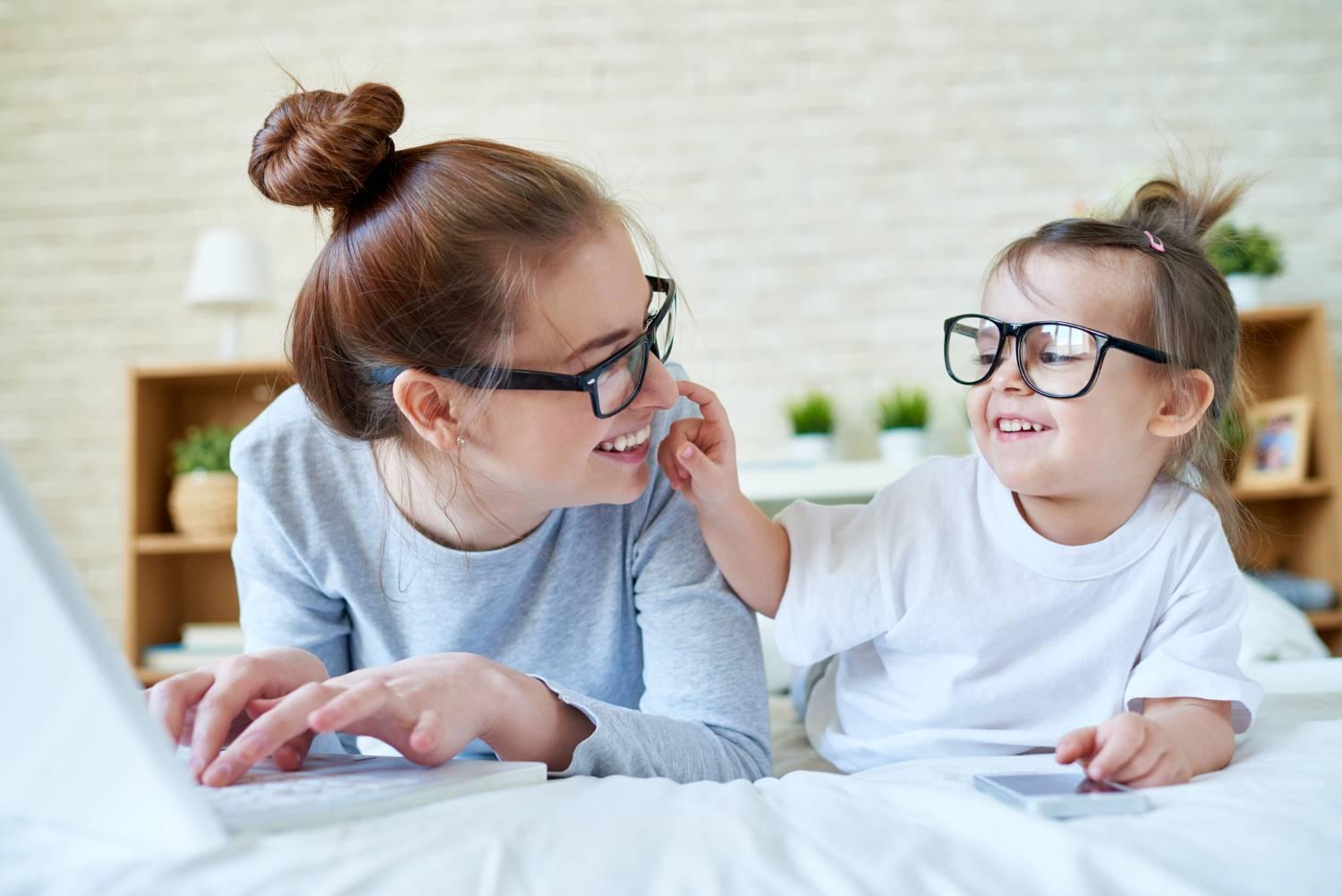 Brillen und Kontaktlinsen: Mutter und Kind albern miteinander herum. Beide tragen eine Brille.