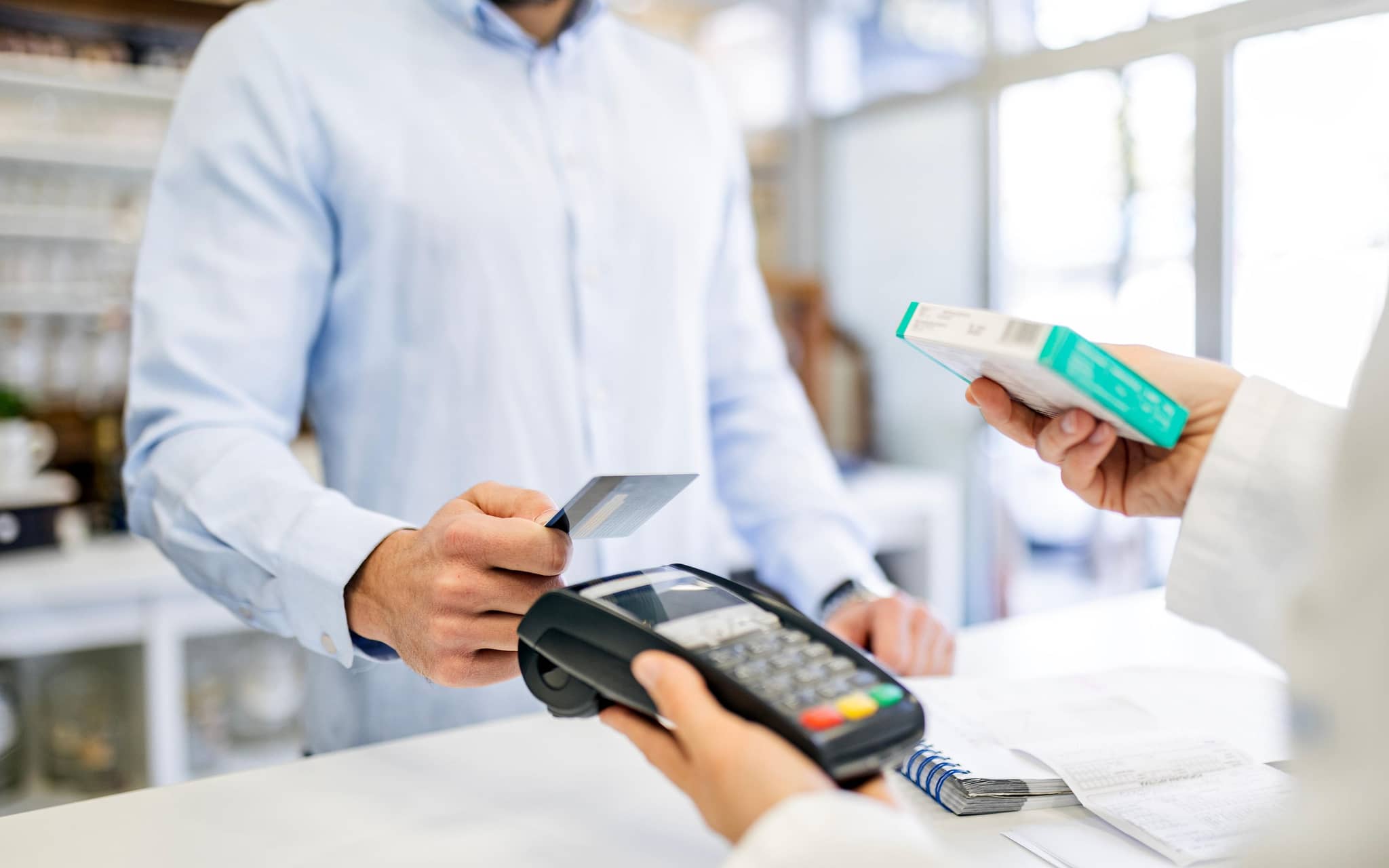 Ein Mann bezahlt seine Medikamente mit einer EC-Karte in einer Apotheke.