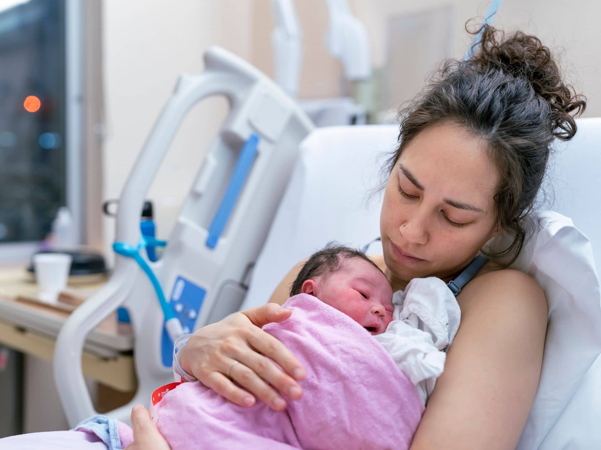 Eine Frau hält ihr neugeborenes Baby auf der Brust.