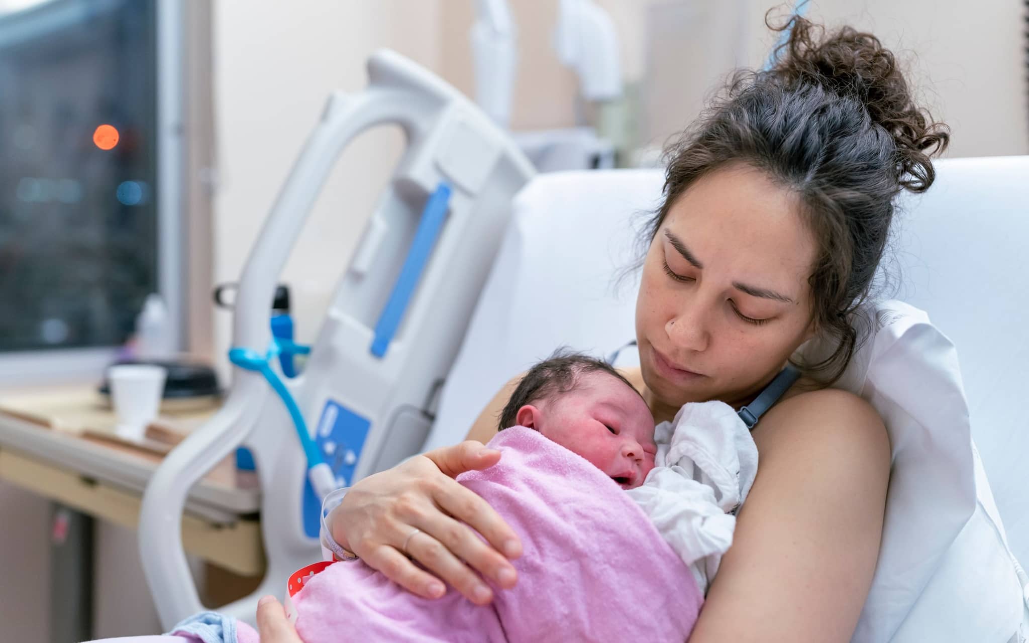 Eine Frau hält ihr neugeborenes Baby auf der Brust.