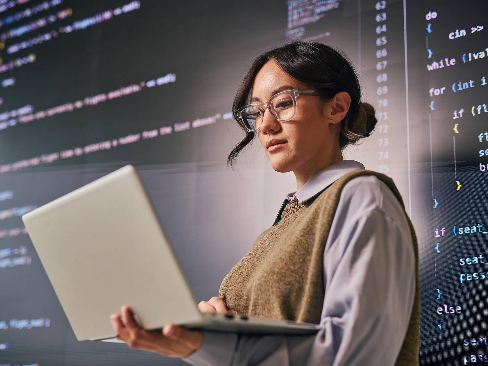 Eine junge Programmiererin mit Code im Hintergrund