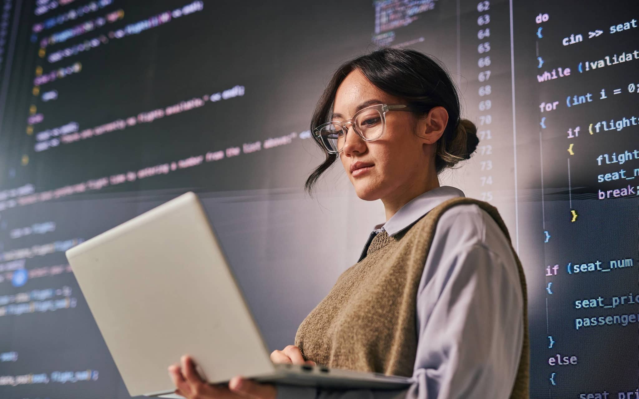 Eine junge Programmiererin mit Code im Hintergrund