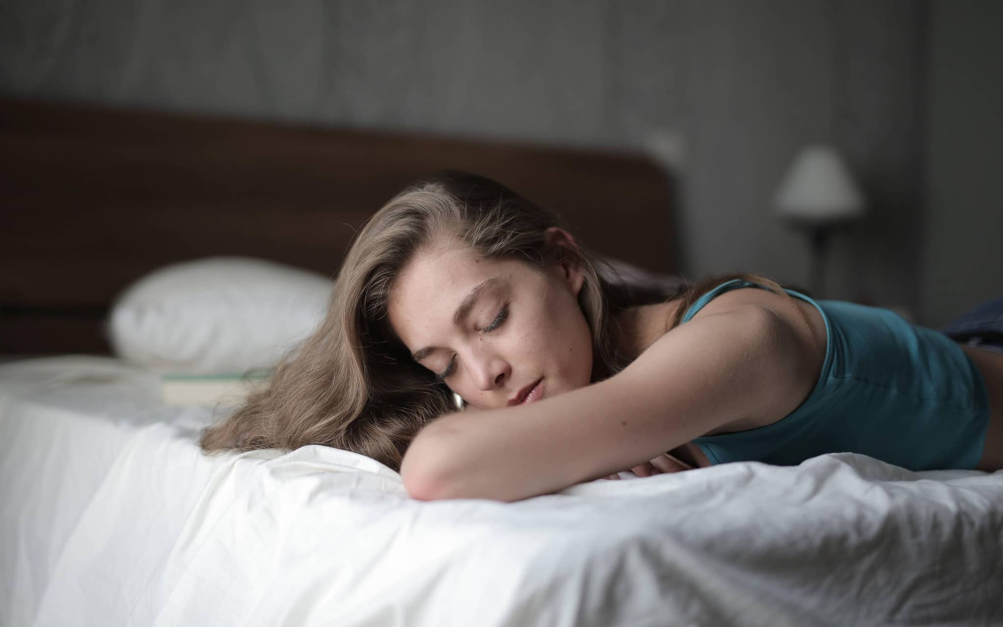 Junge Frau schläft friedlich im Bett.
