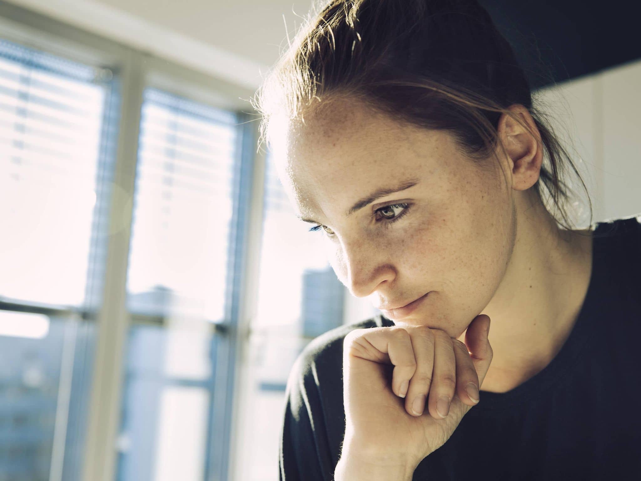 Junge Frau guckt nachdenklich.