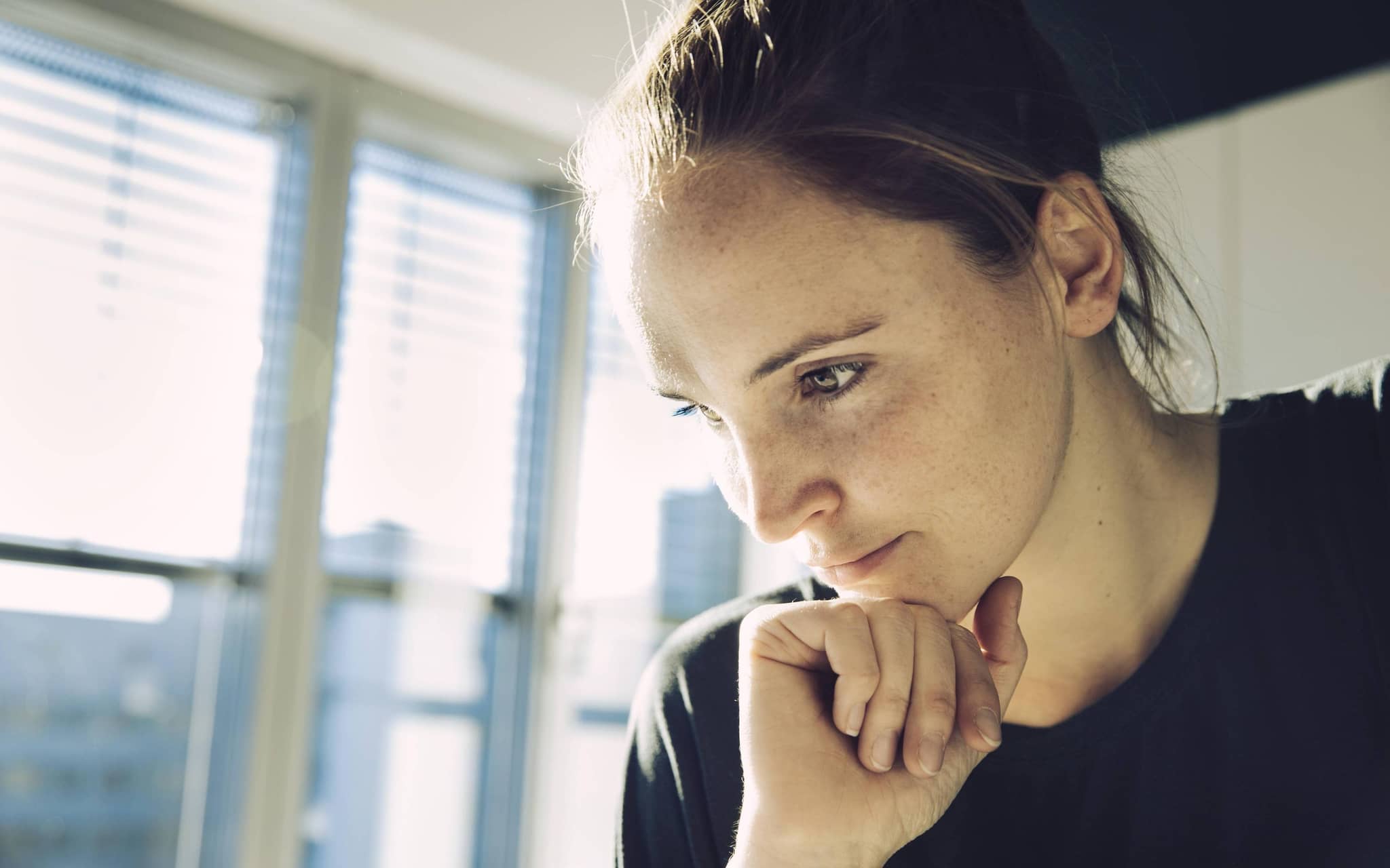 Junge Frau guckt nachdenklich.