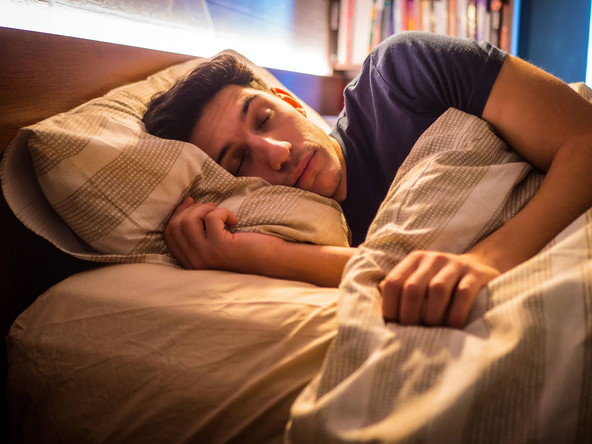 Ein Mann liegt im Bett und schläft.