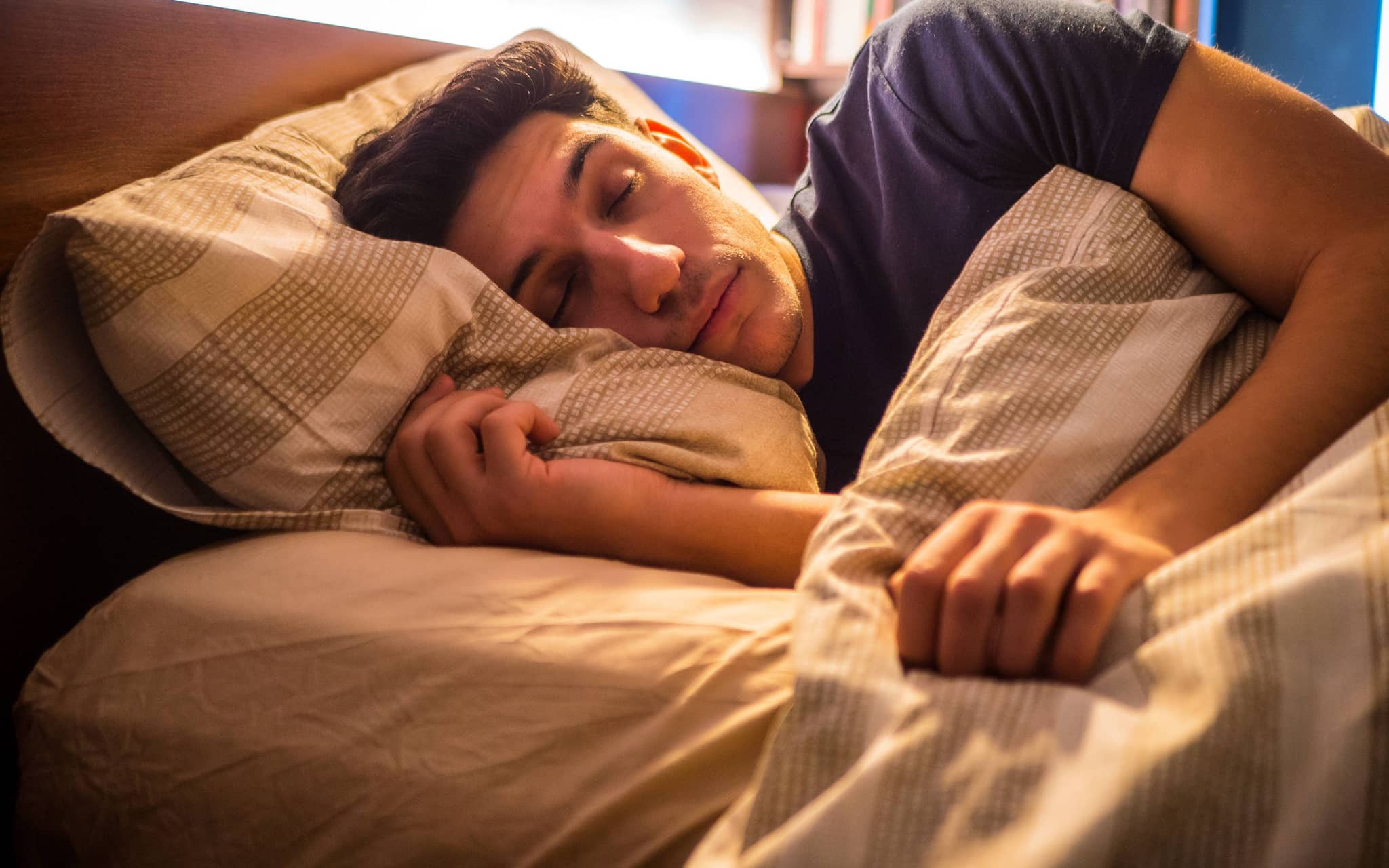 Ein Mann liegt im Bett und schläft.