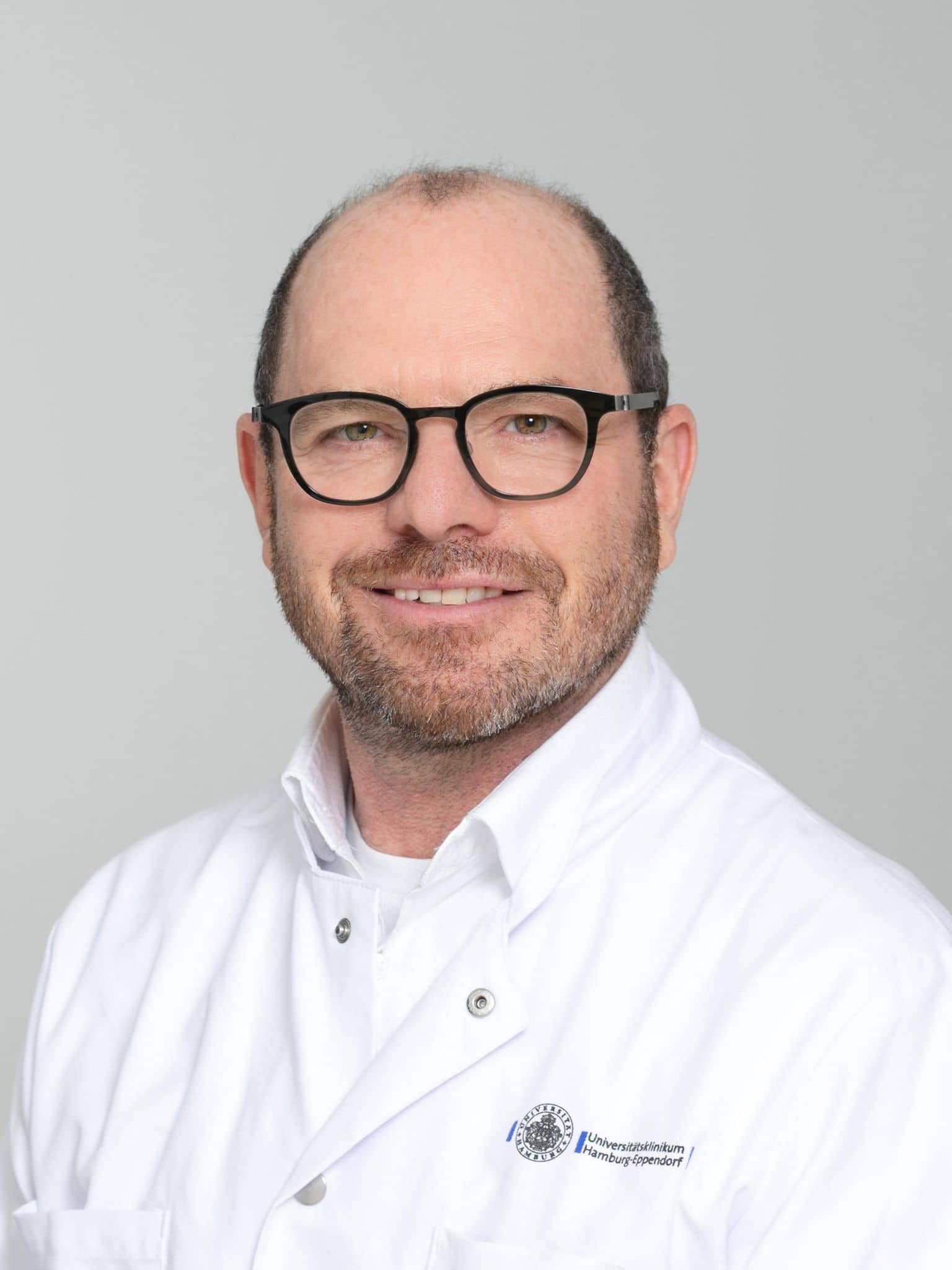 Bild: Portrait Prof. Dr. Dr. Irwin Reiss , ein Mann mit weißem Hemd, dunkler Brille und lichtem Haar.
