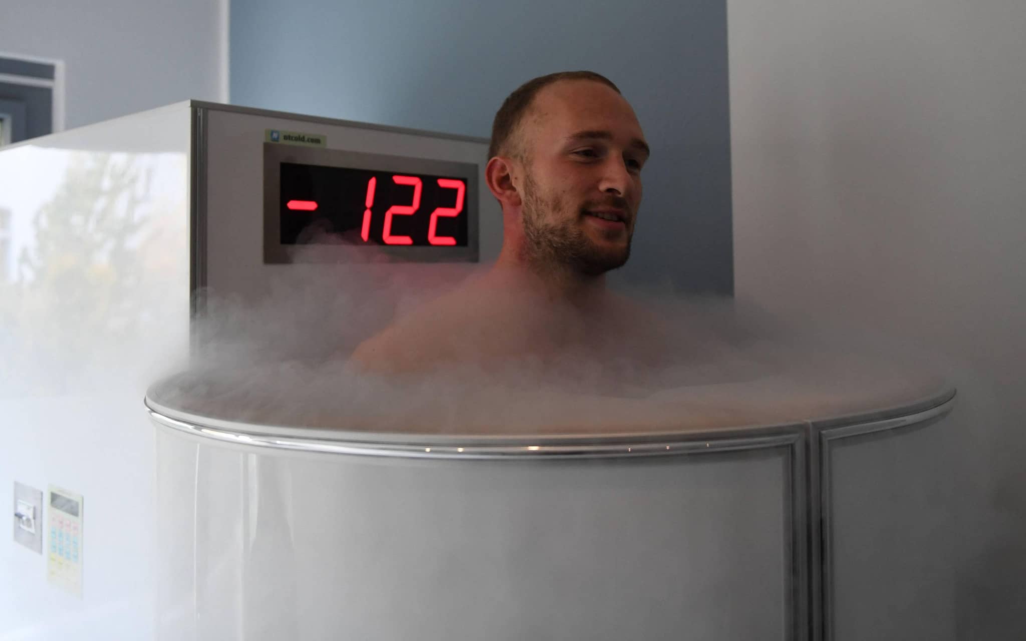 Ein Mann steht in einer Ganzkörper-Kältekammer, die eine Temperatur von minus 122 Grad anzeigt.