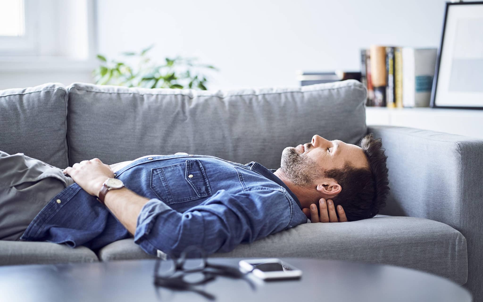 Mann ruht sich auf dem Sofa aus.