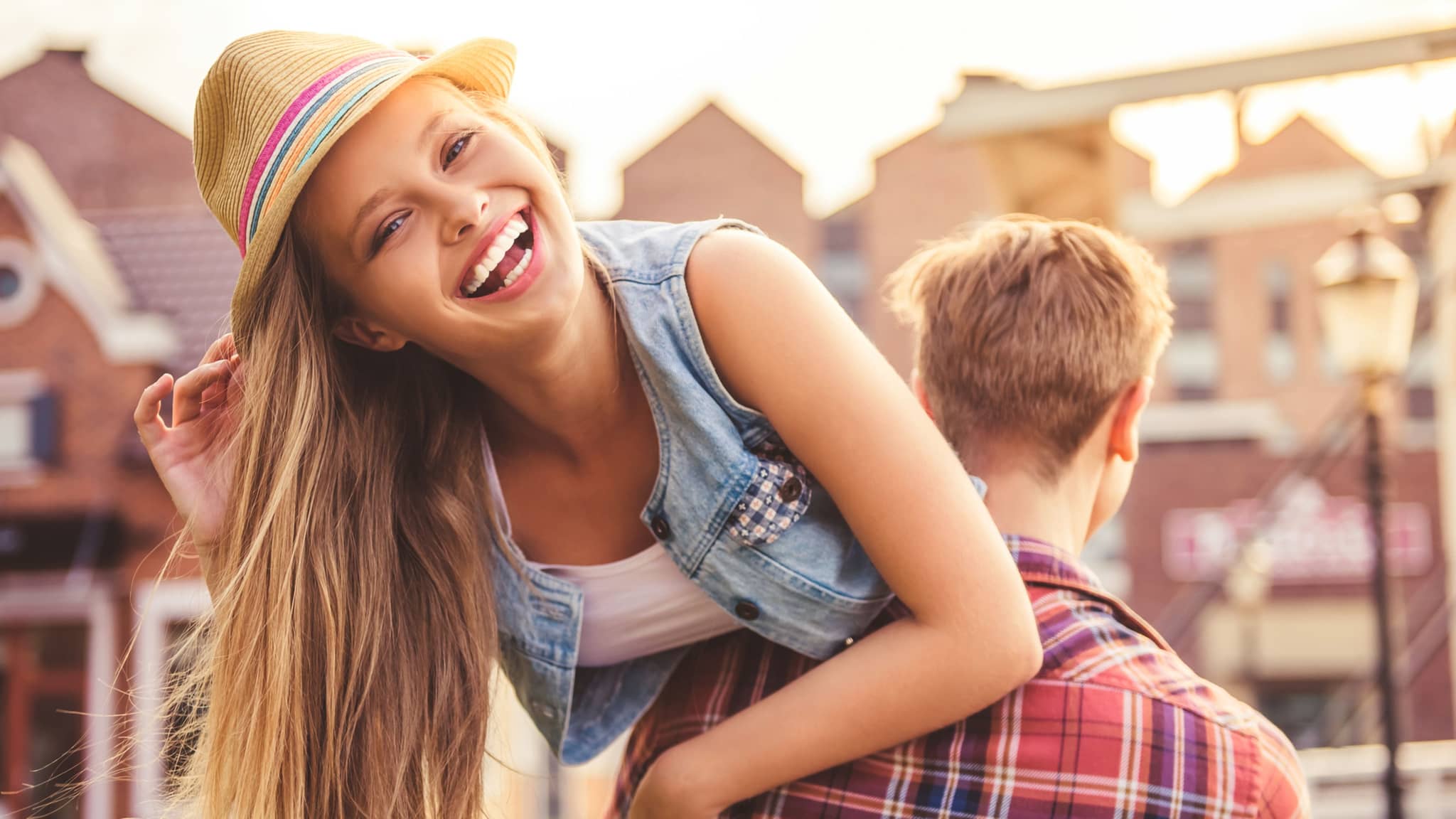 Mädchen lachend auf der Schulter eines Jungen