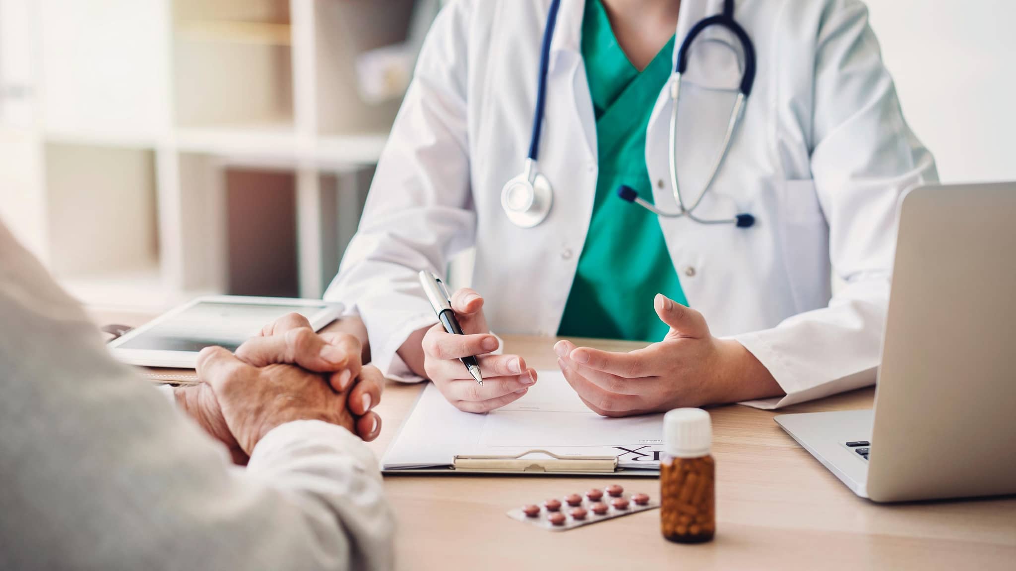 Arzt und patient diskutieren etwas am Schreibtisch