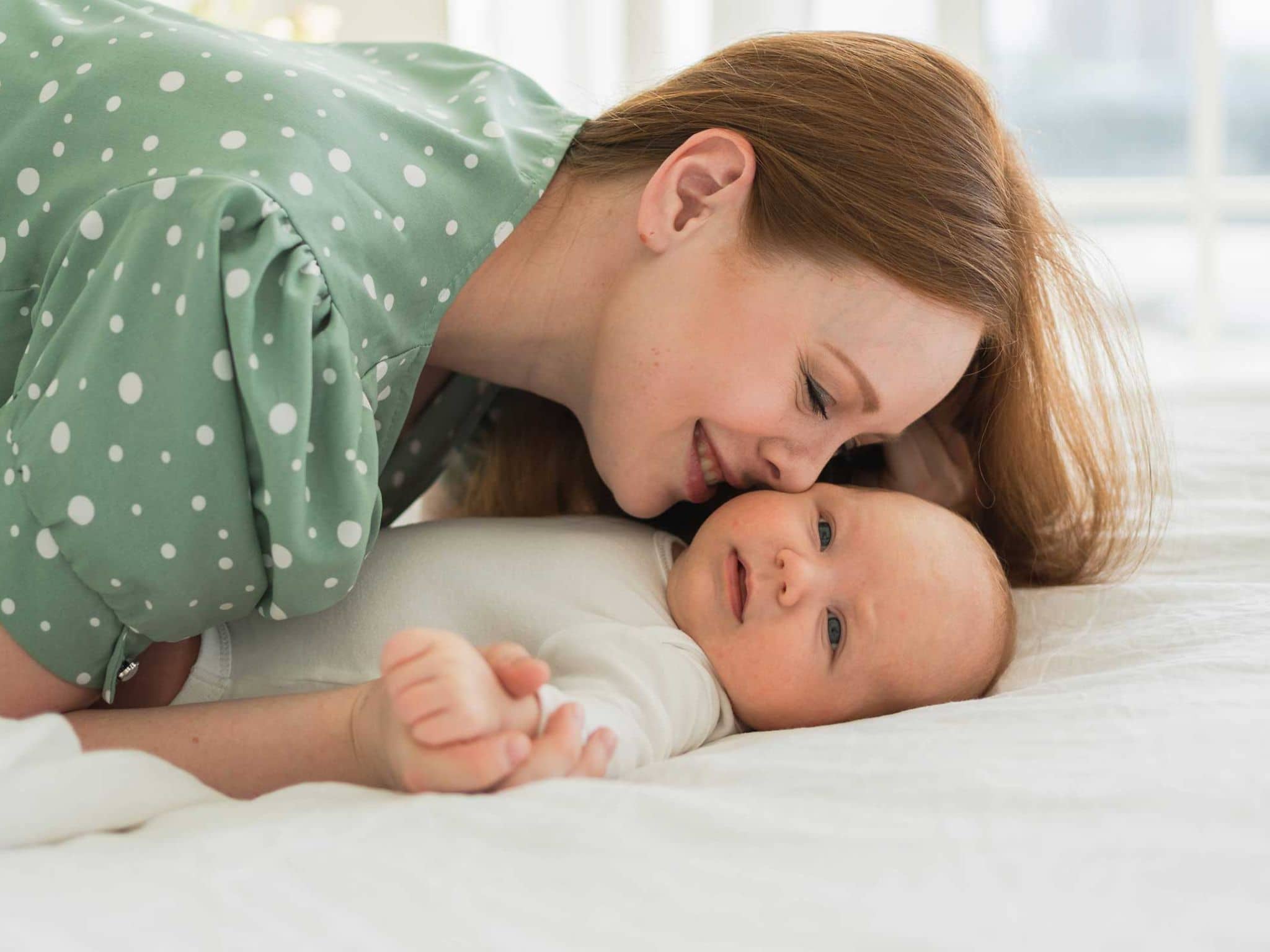 Mutter legt liebevoll ihre Nase an das Gesicht ihres Babys