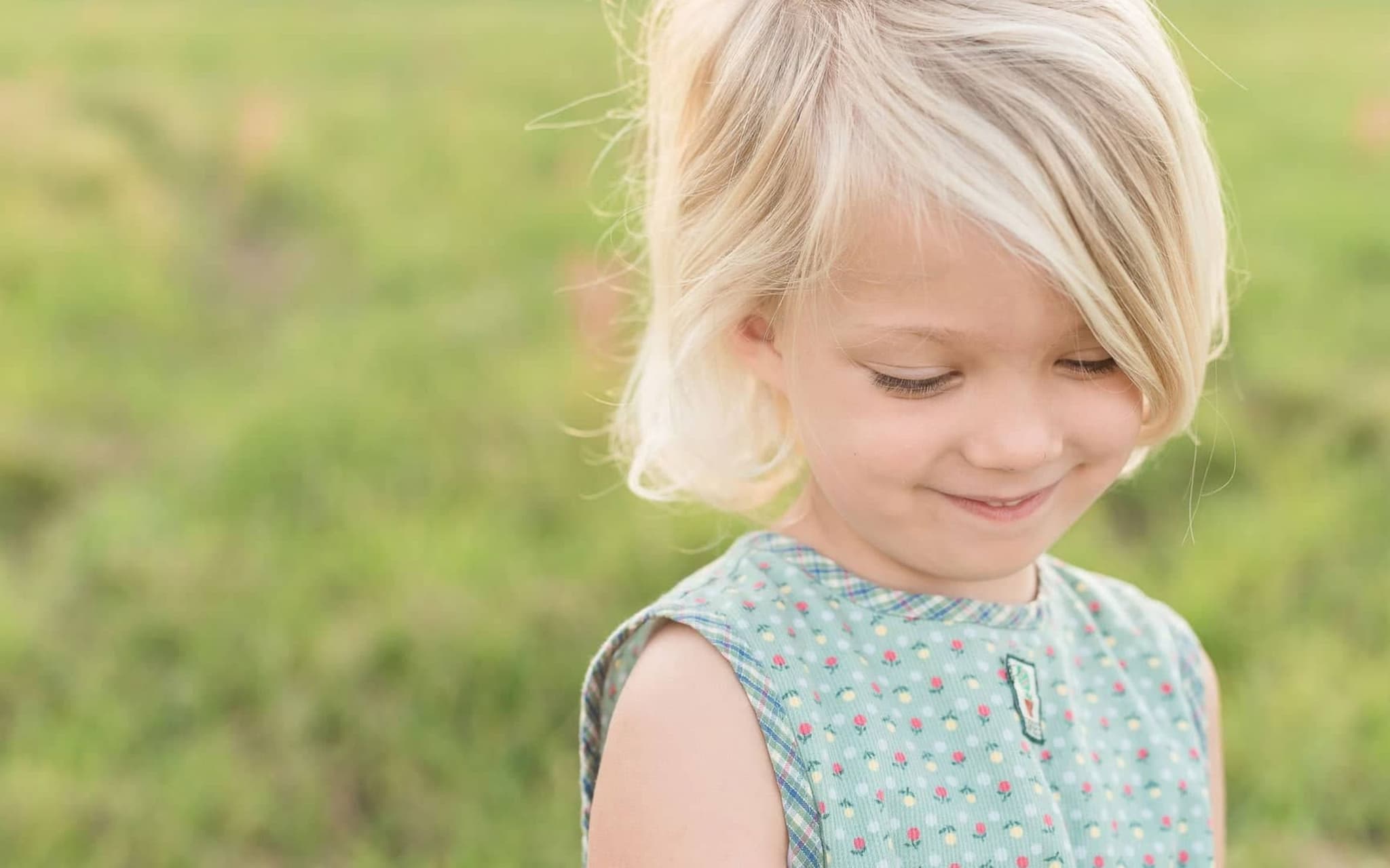 U7 Untersuchung: Kleines blondes Mädchen schaut schüchtern lächelnd auf den Boden.