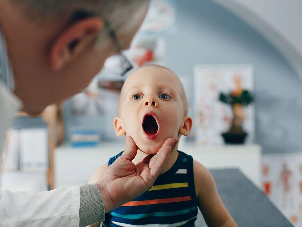 U8 Untersuchung: Arzt schaut einem kleinen Jungen in den Mund.