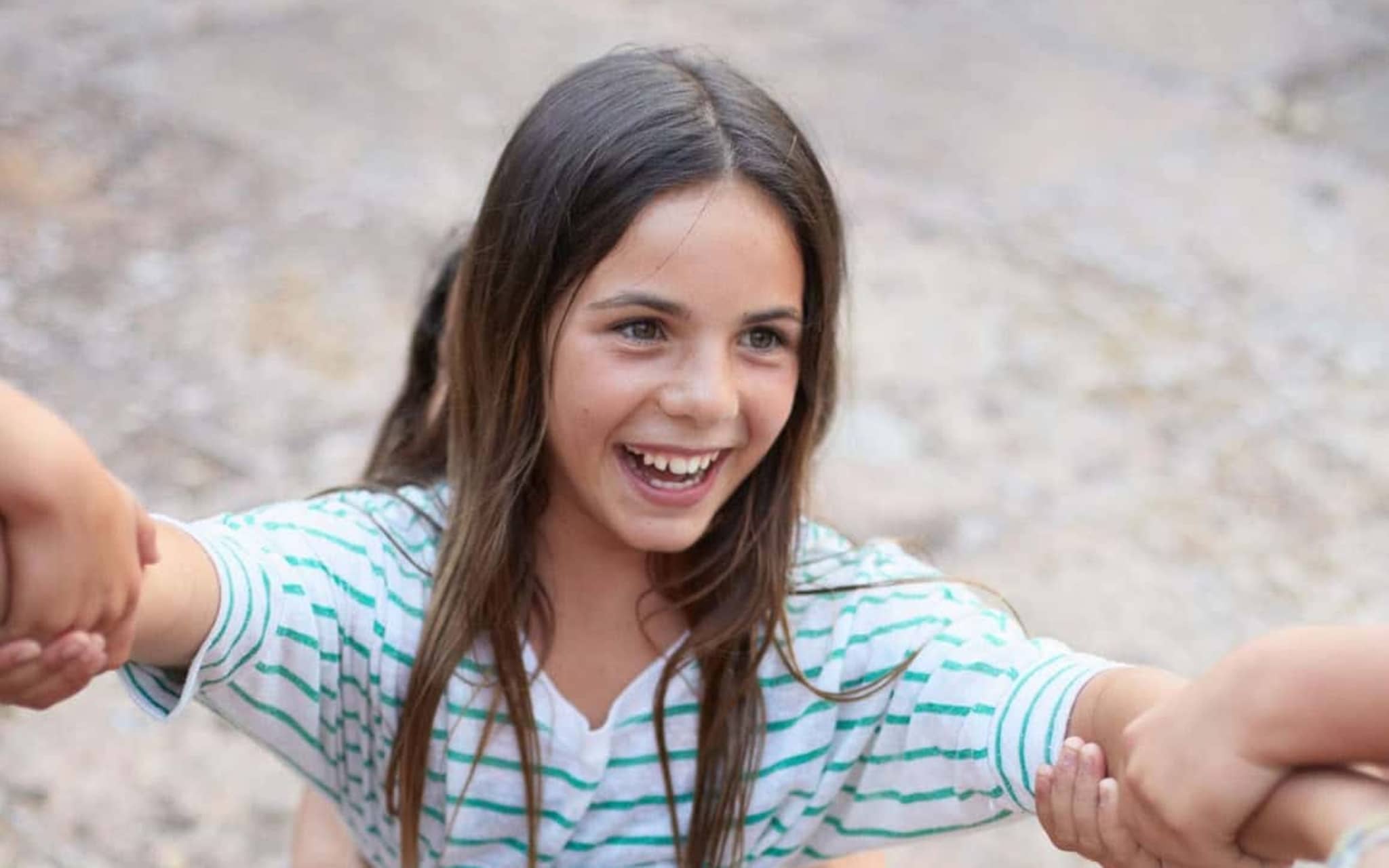 U10 Untersuchung: Lachendes Mädchen spielt mit drei anderen Kindern.