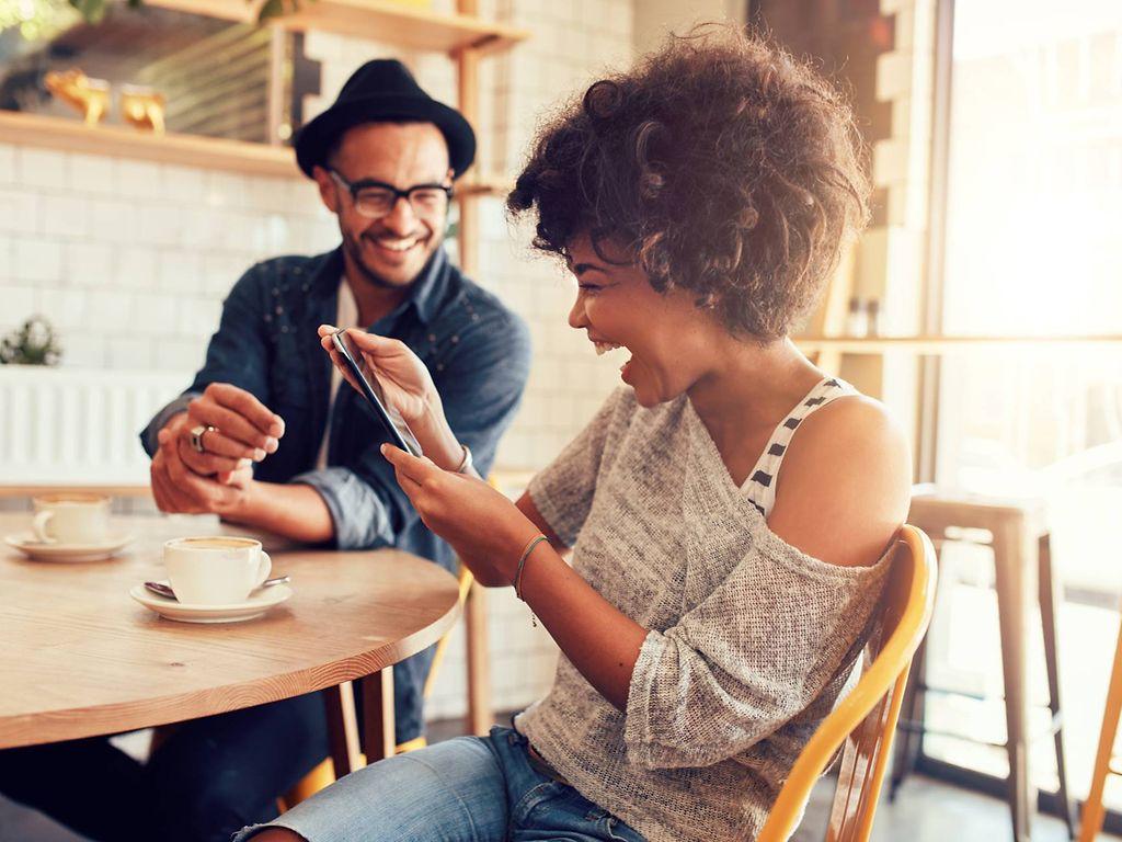 Gesundheitsuntersuchung: Zwei Freunde sitzen fröhlich zusammen im Café