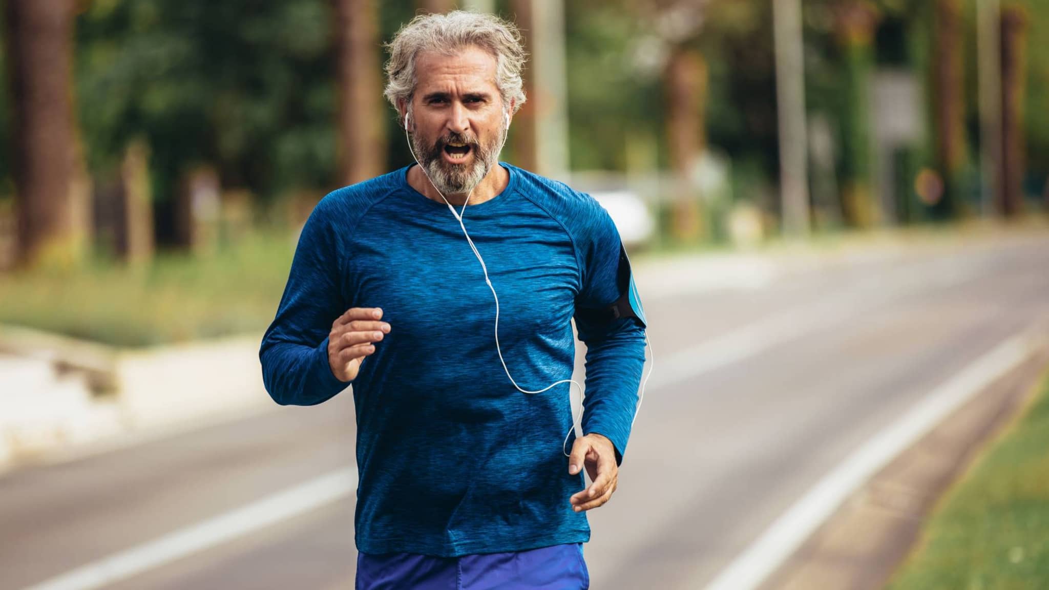 Sportmedizinische Untersuchung: Älterer Mann joggt Straße entlang