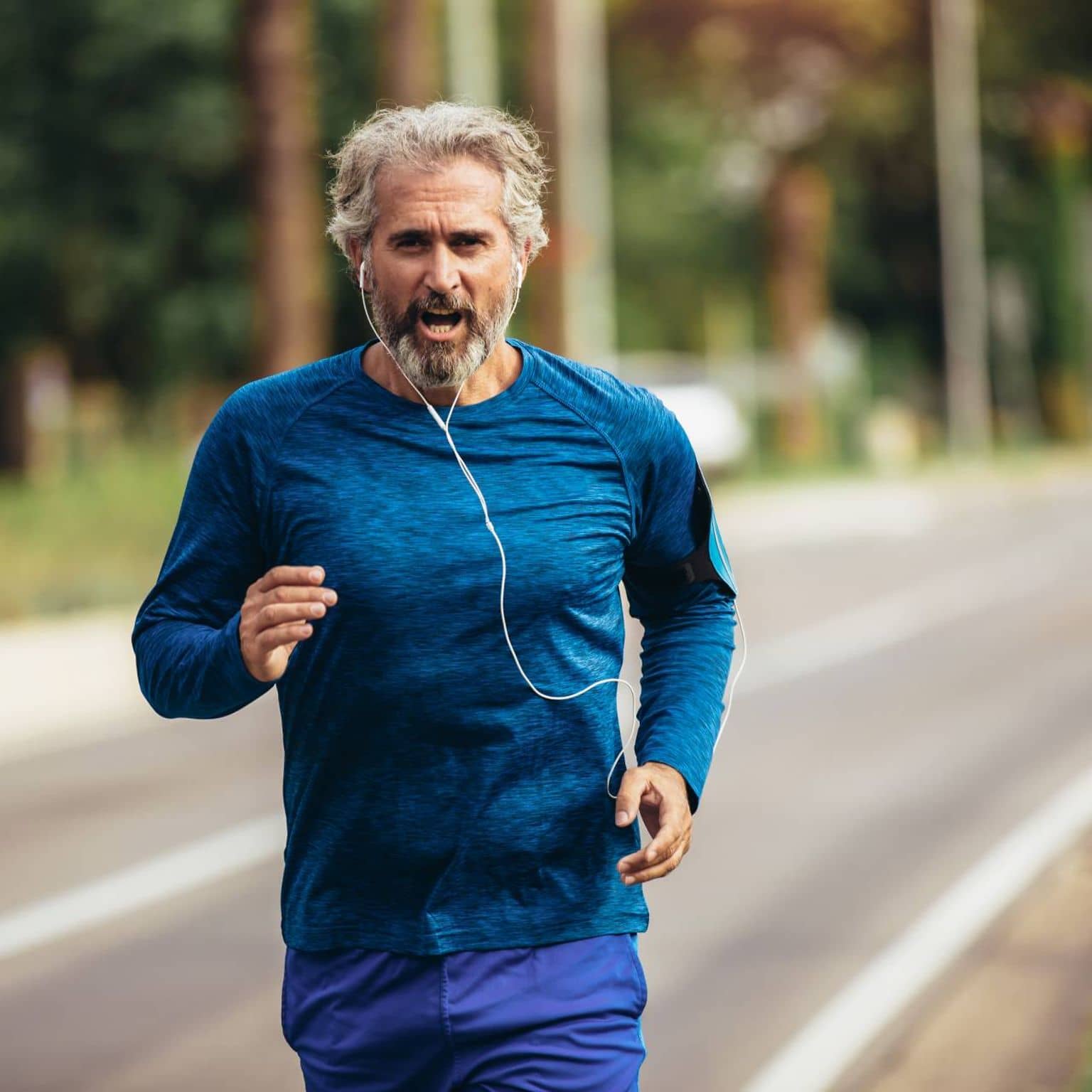 Sportmedizinische Untersuchung: Älterer Mann joggt Straße entlang