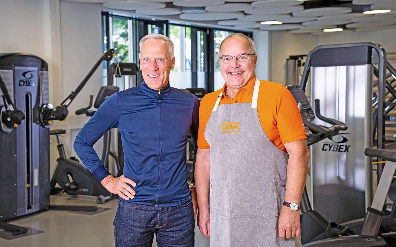 Prof. Dr. Ingo Froböse und Helmut Gote stehen nebeneinander im Fitnessstudio