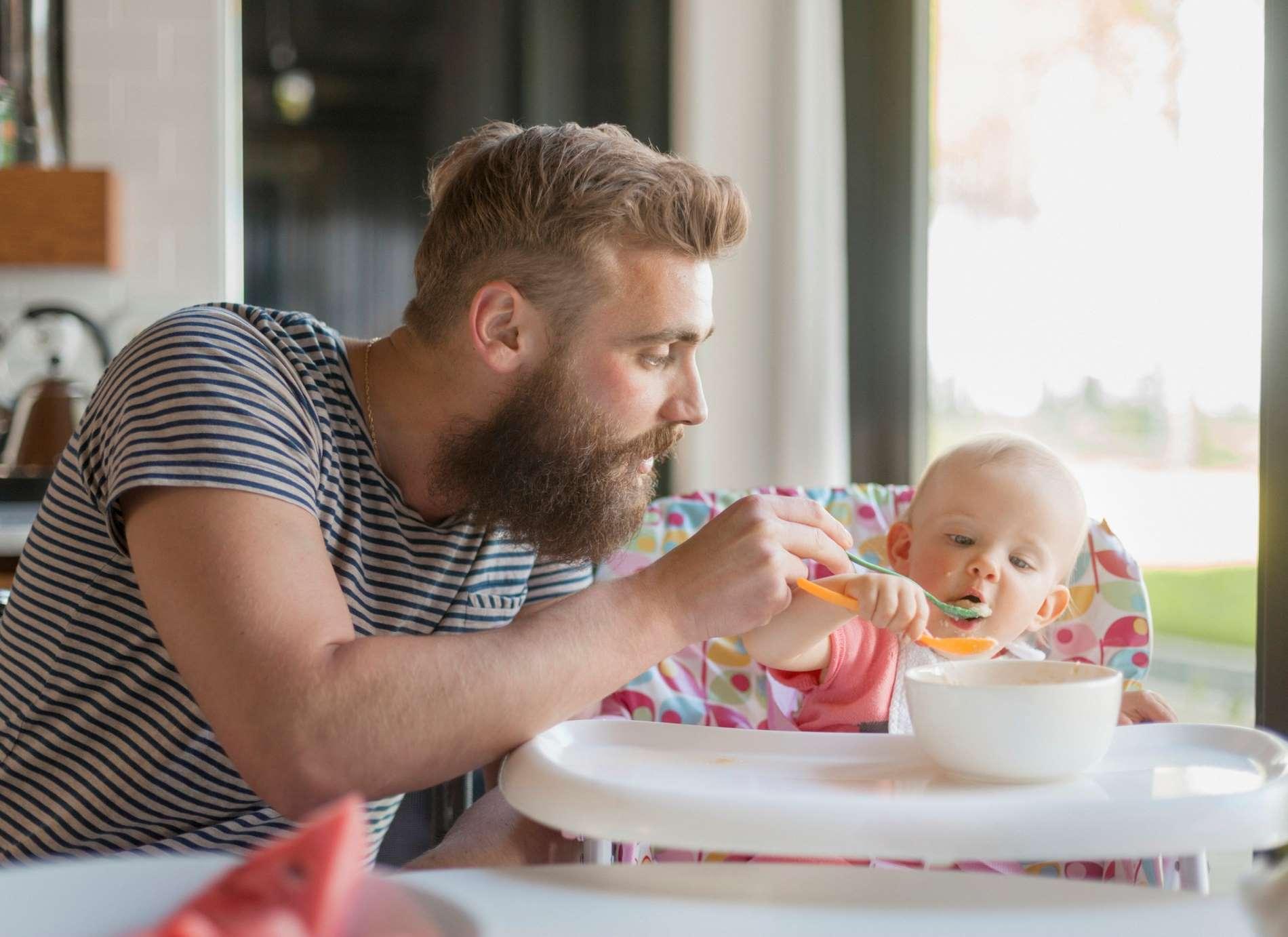 Onlineseminar Ernährung: Mann füttert Baby mit Brei