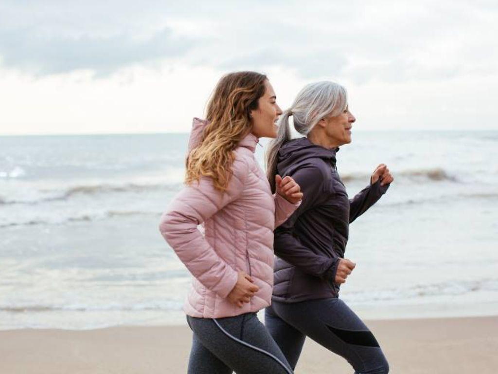 DAK Herz-Kreislauf Coaching: Ältere Frau läuft mit ihrer Tochter am Strand