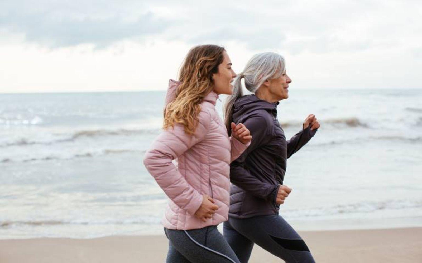 DAK Herz-Kreislauf Coaching: Ältere Frau läuft mit ihrer Tochter am Strand