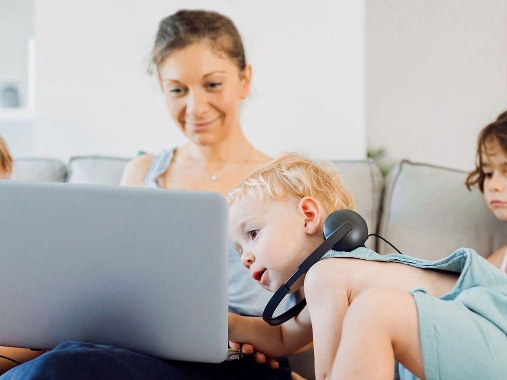 Symbolbild Videoberatung: Mutter und Kinder schauen gemeinsam auf ein Notebook.