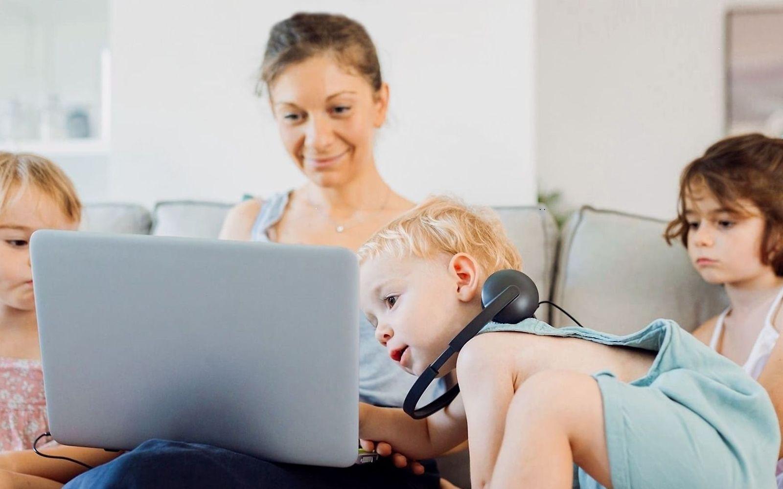 Symbolbild Videoberatung: Mutter und Kinder schauen gemeinsam auf ein Notebook.