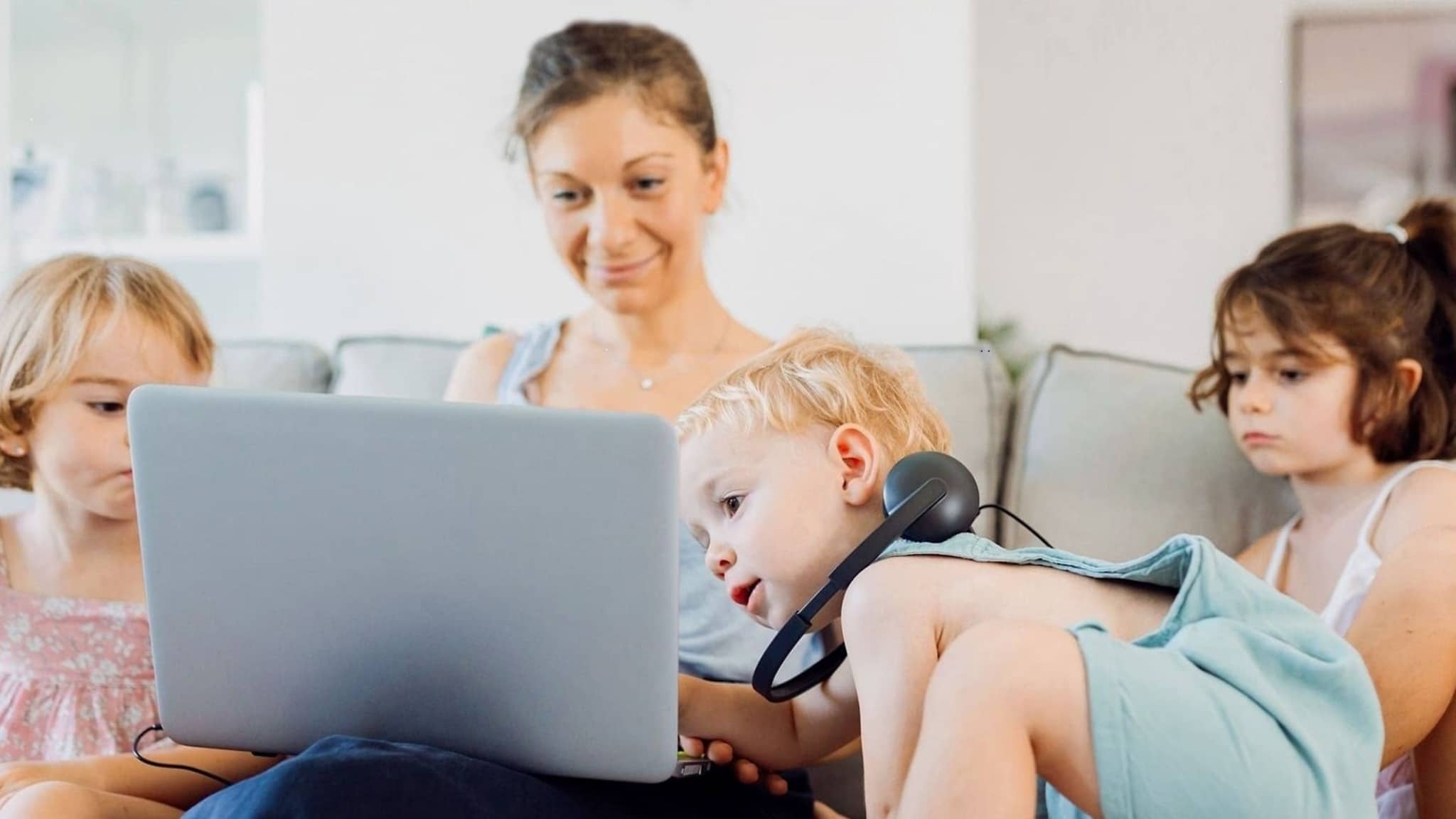 Symbolbild Videoberatung: Mutter und Kinder schauen gemeinsam auf ein Notebook.