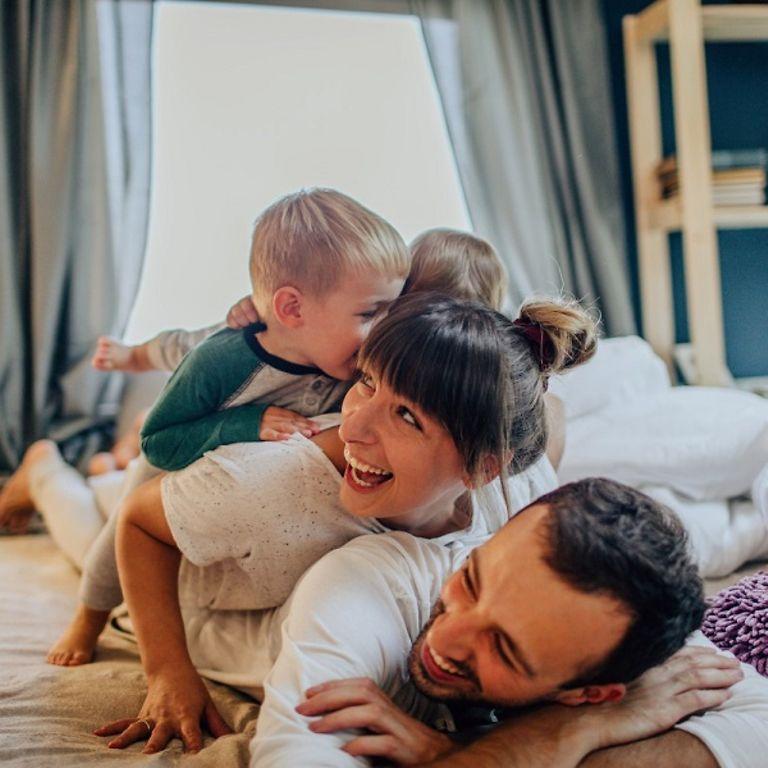 Kunden-Newsletter: Familie spielt gemeinsam morgens im Bett